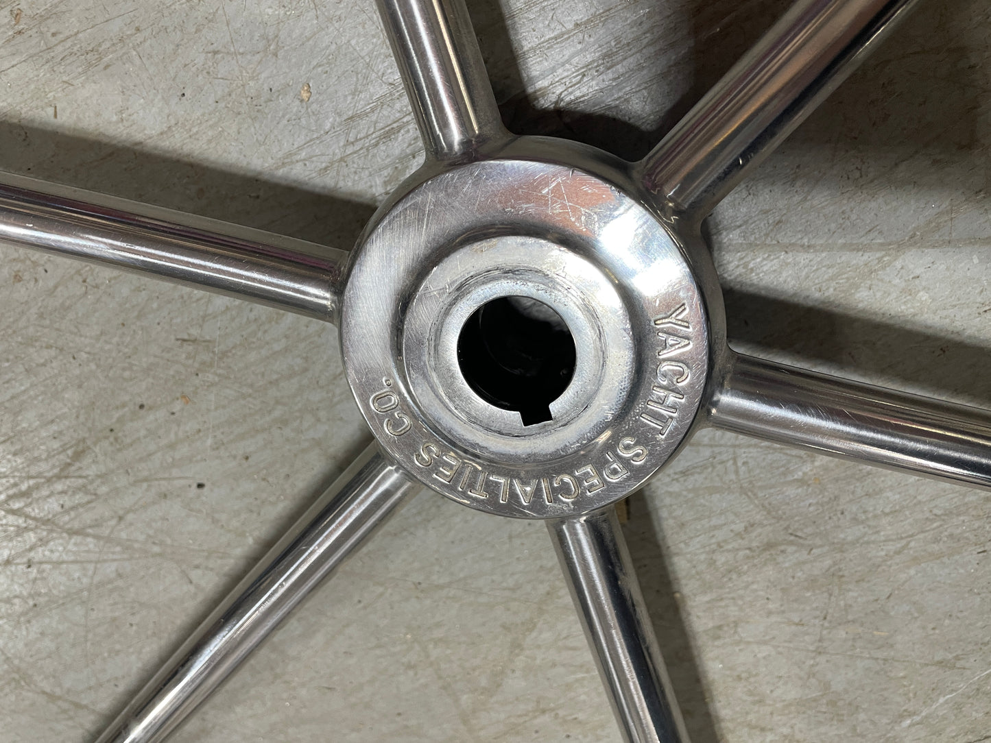 Close-up of a metallic wheel hub with 'Yacht Specialties' branding on a textured surface.