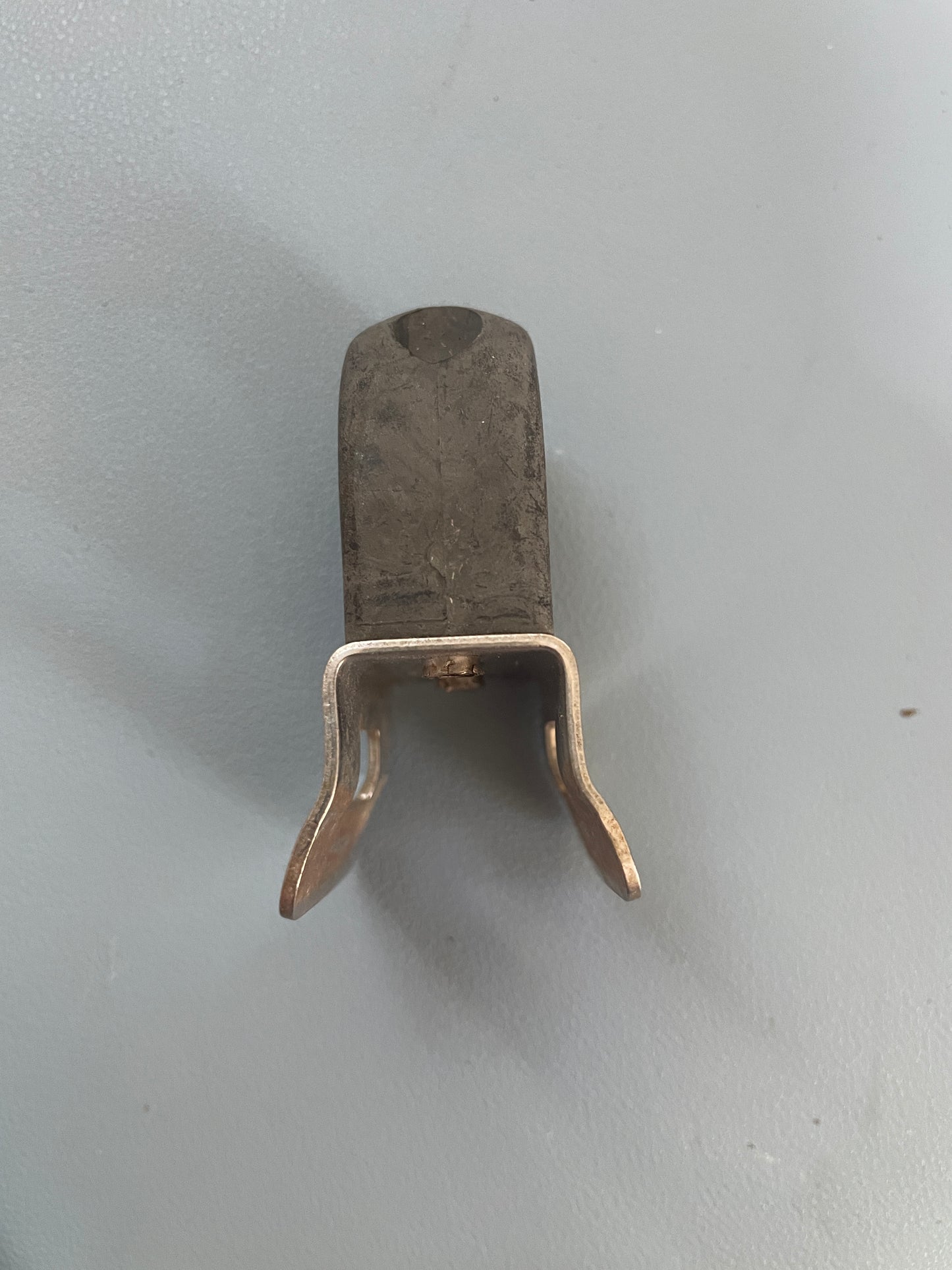 Metallic object with a hook on a gray background