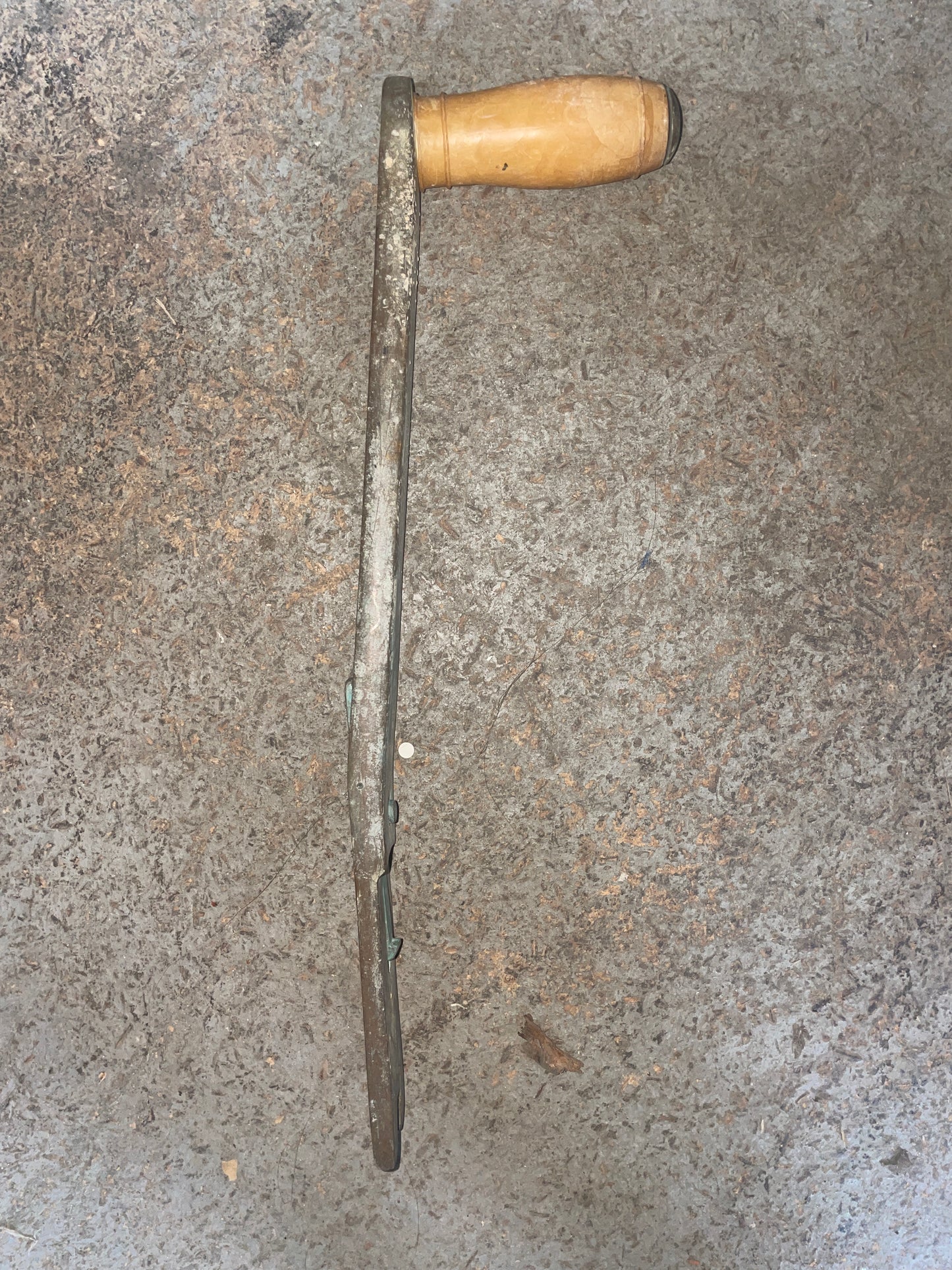 Tool with wooden handle on a textured gray surface