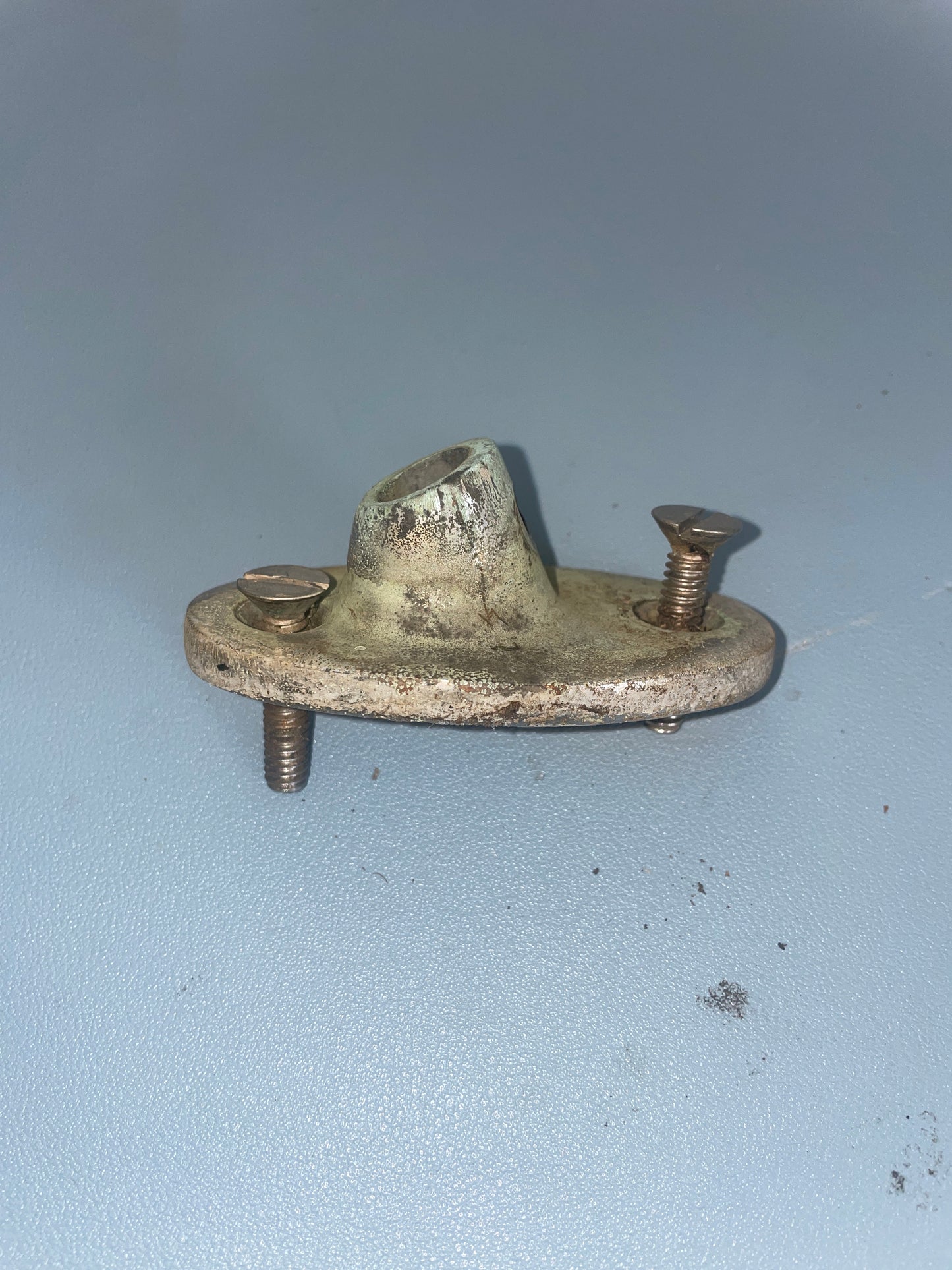 Metal bracket with screws on a light blue background