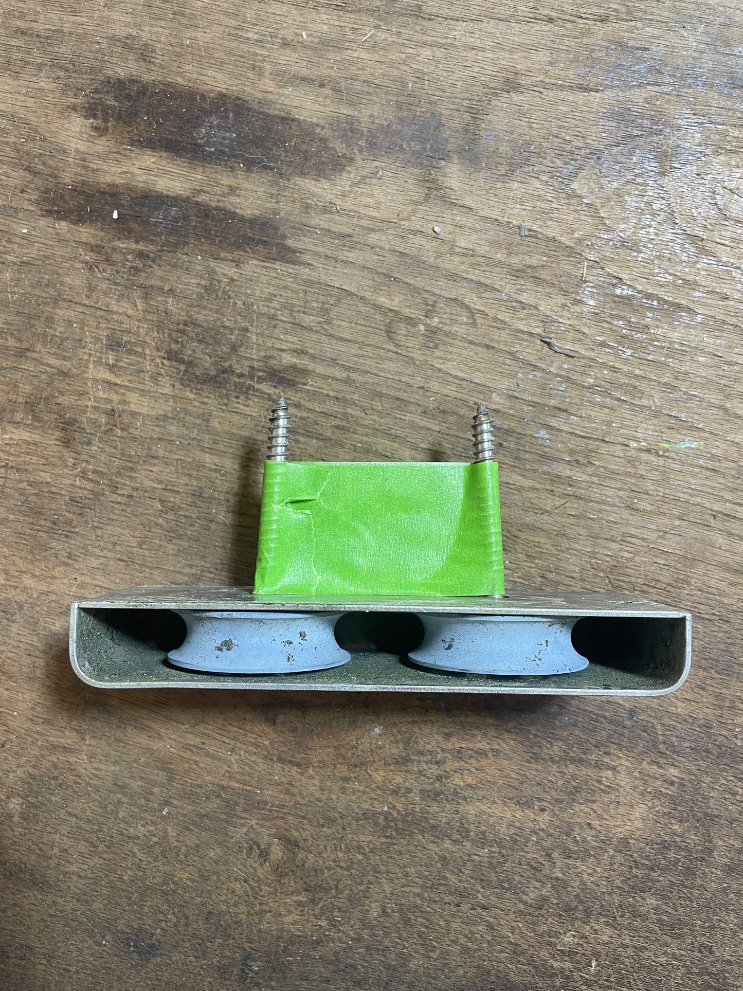 Small metal object with a green label on a wooden surface