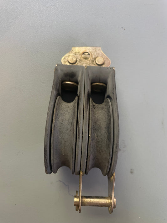 Metal pulley system on a plain background