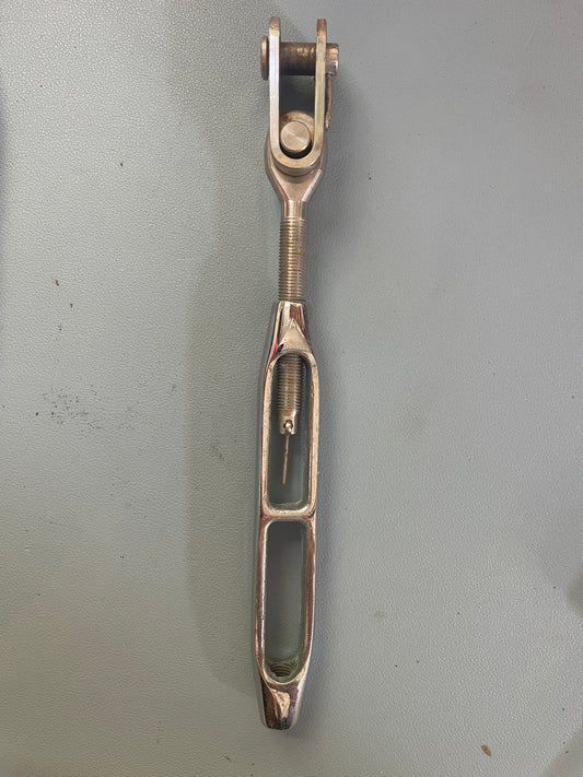 Metallic tool with a coiled spring on a gray background