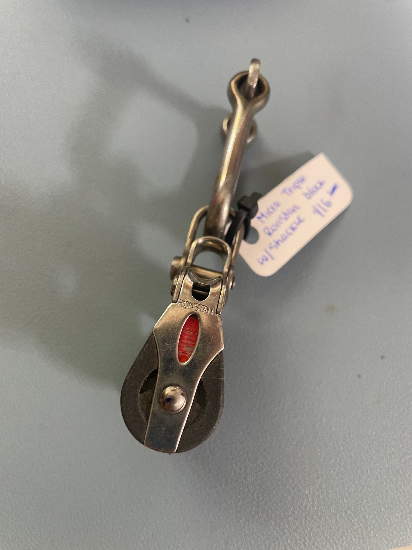 Metallic pulley system with a label on a gray background