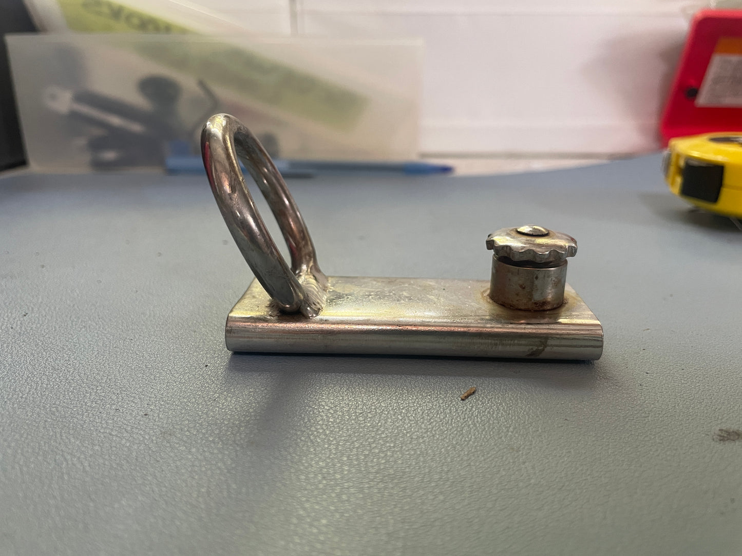 Metallic object with a handle on a gray surface