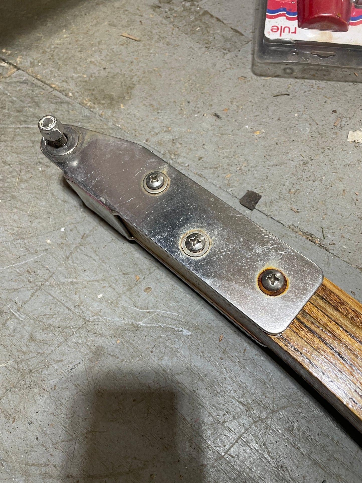 Metal tool with wooden handle on a concrete surface