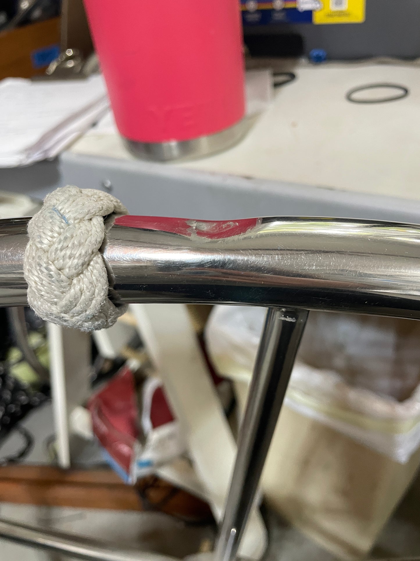 Metal pole with a rope knot in a cluttered indoor setting
