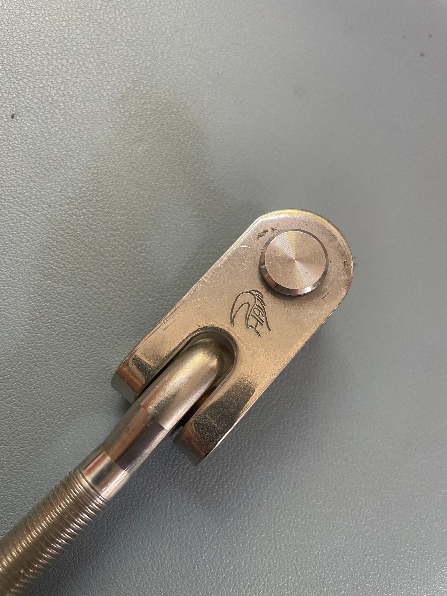 Metallic tool with a handle on a gray background