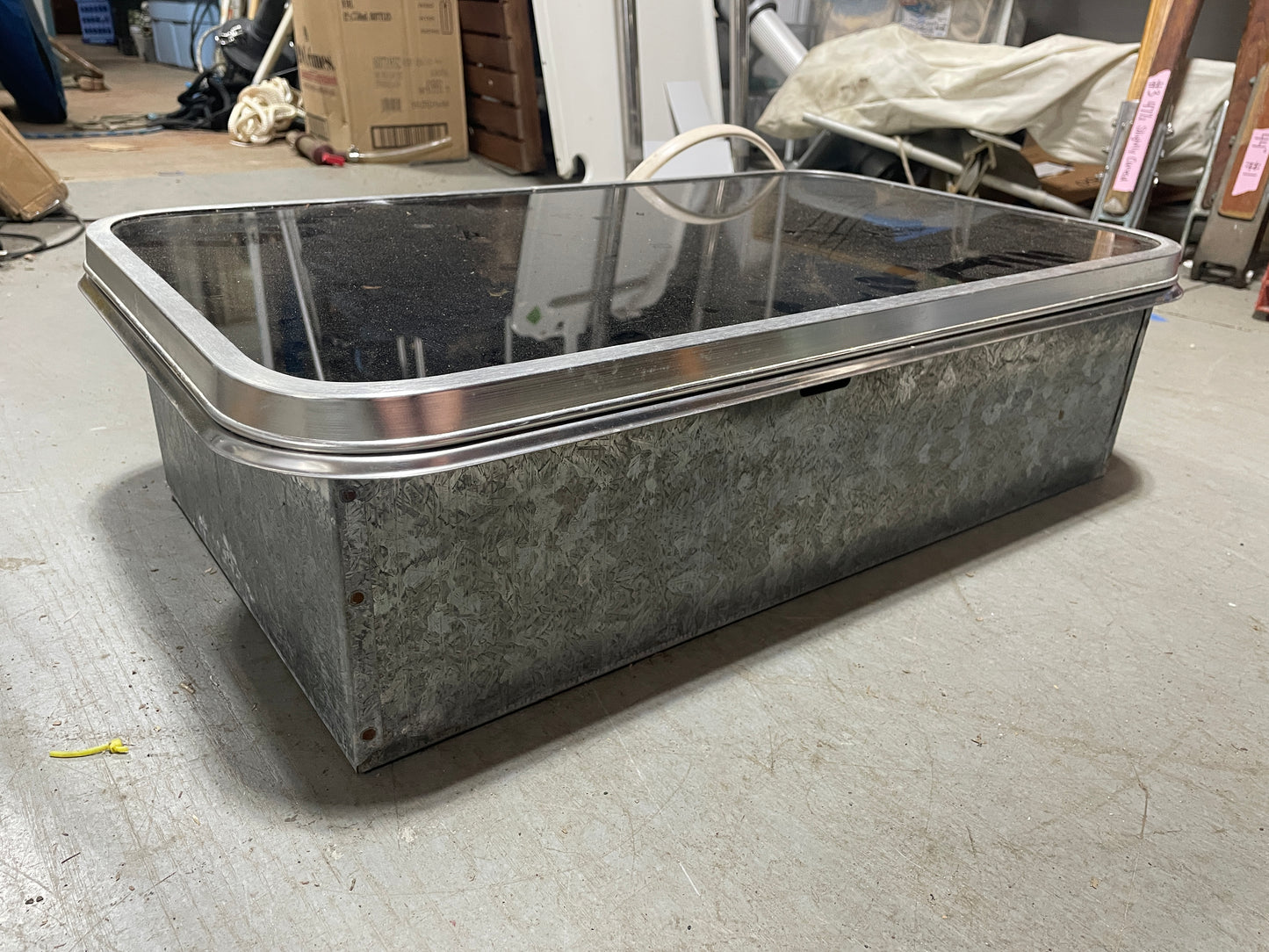 Metal trough on a concrete floor with a warehouse background