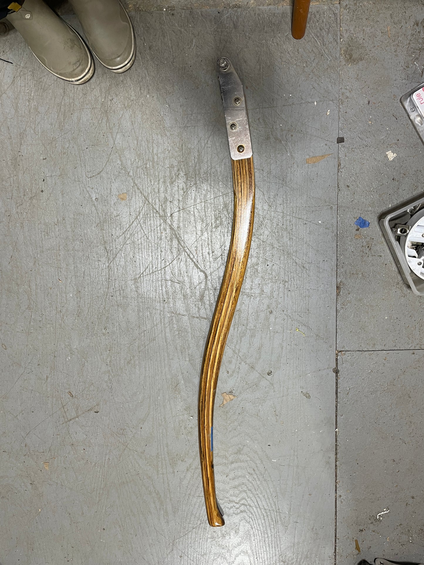 Metallic object with a curved handle on a gray floor
