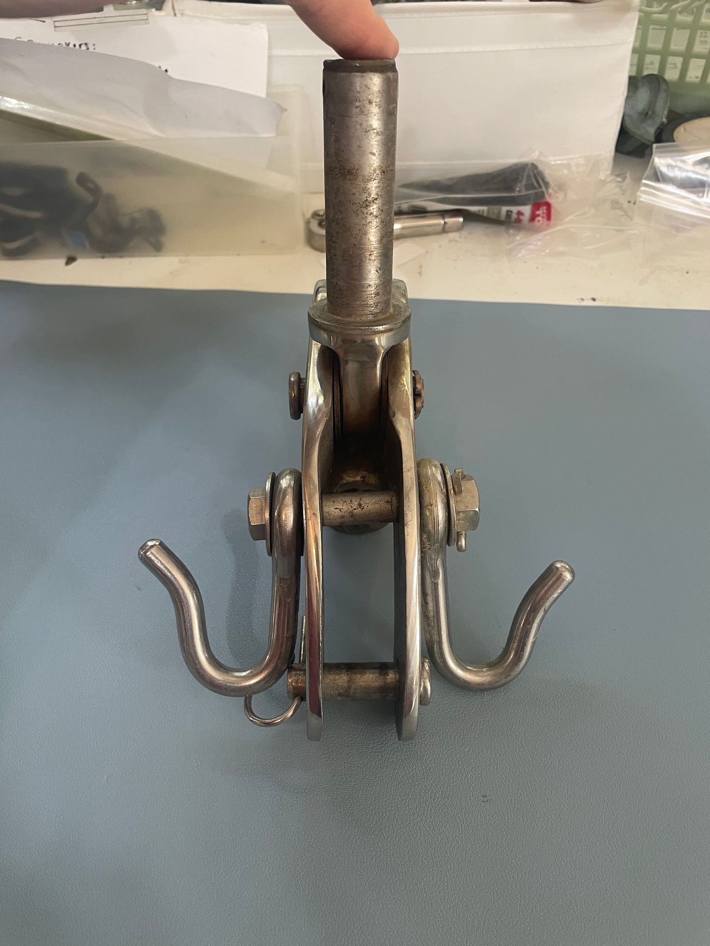 Metallic clamp or fixture on a gray surface with a blurred background