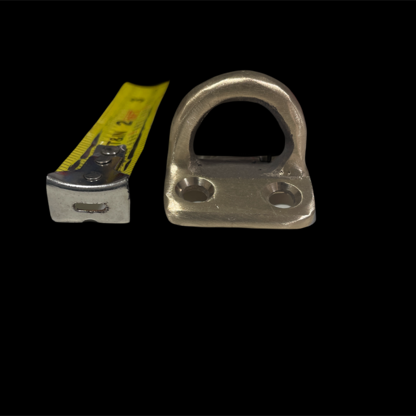 Metal shackle with a measuring tape for scale on a black background