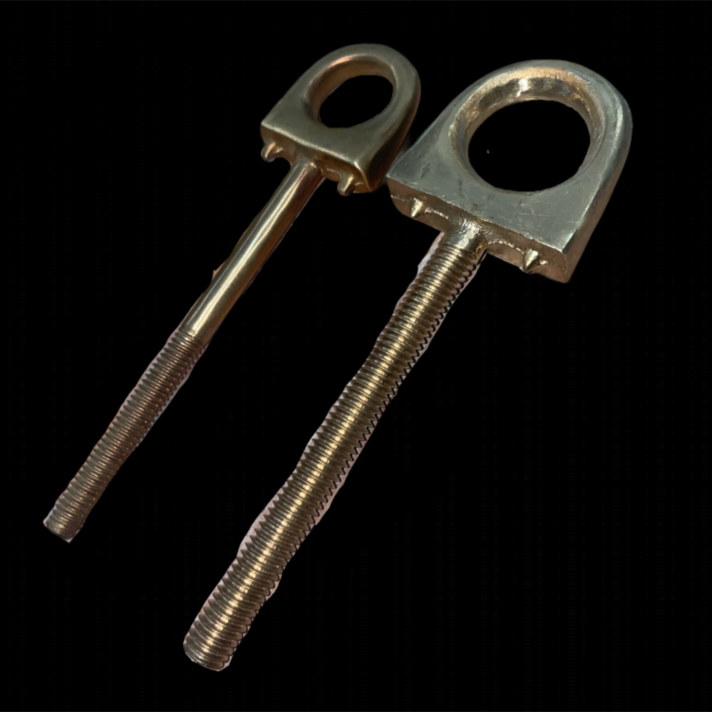 Two metal eye bolts on a black background