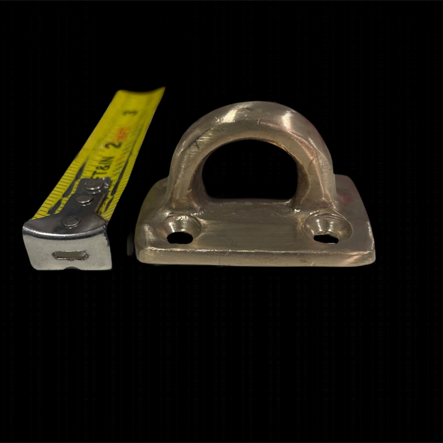 Metal pulley system with a measuring tape for scale on a black background