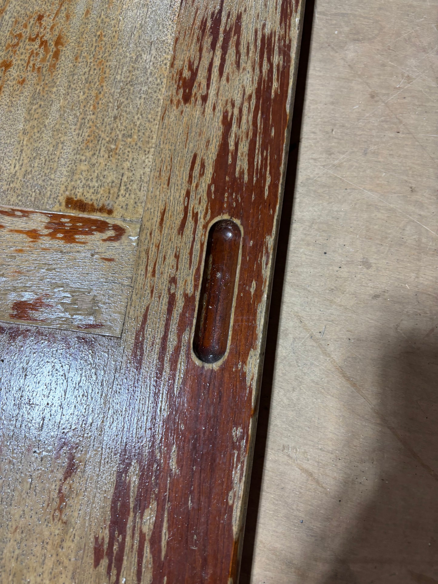 Close-up of a wooden surface with a slot and visible wear
