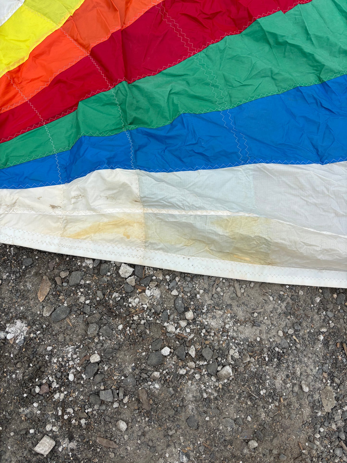 Colorful fabric with red, green, blue, and yellow sections on a concrete surface.