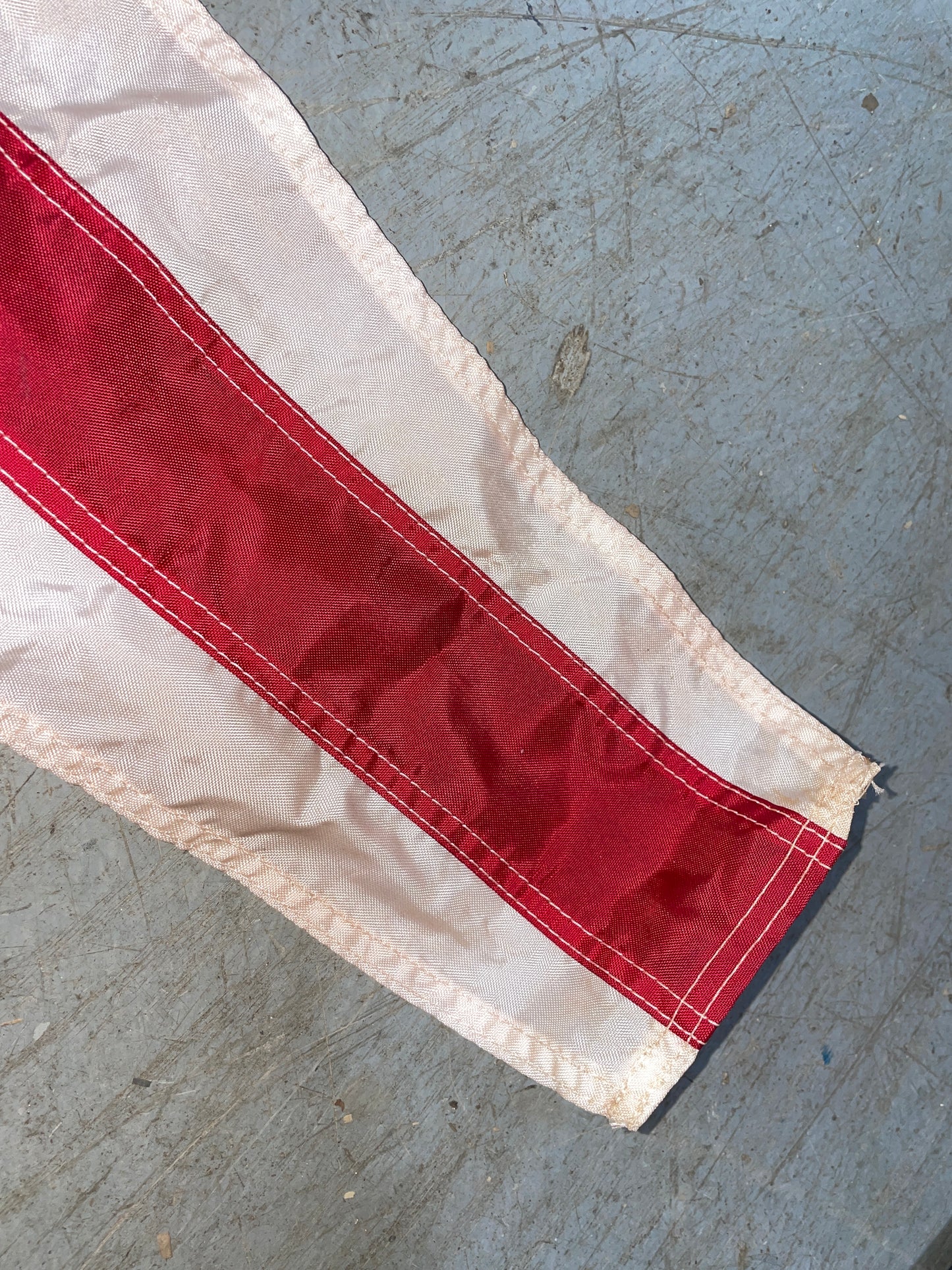 Red and white fabric strip on a gray concrete surface