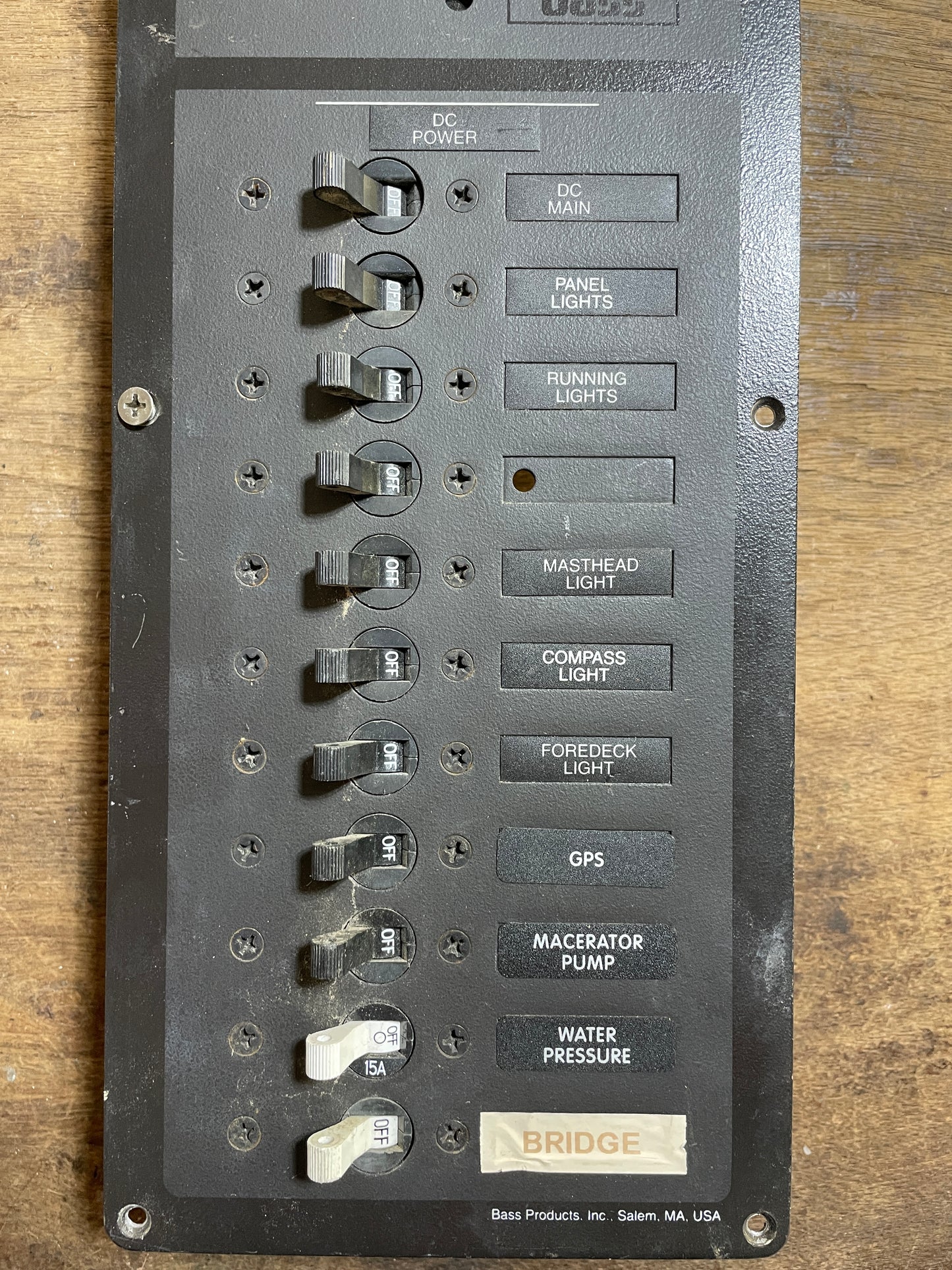 Control panel with various switches on a wooden surface