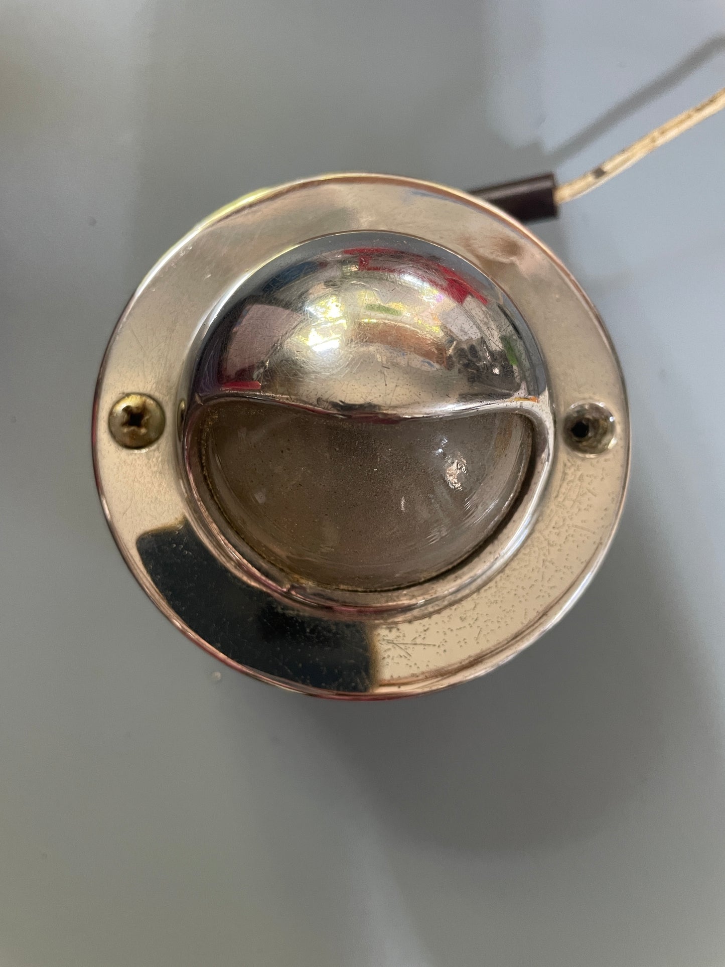 Metallic circular component with a reflective surface on a gray background