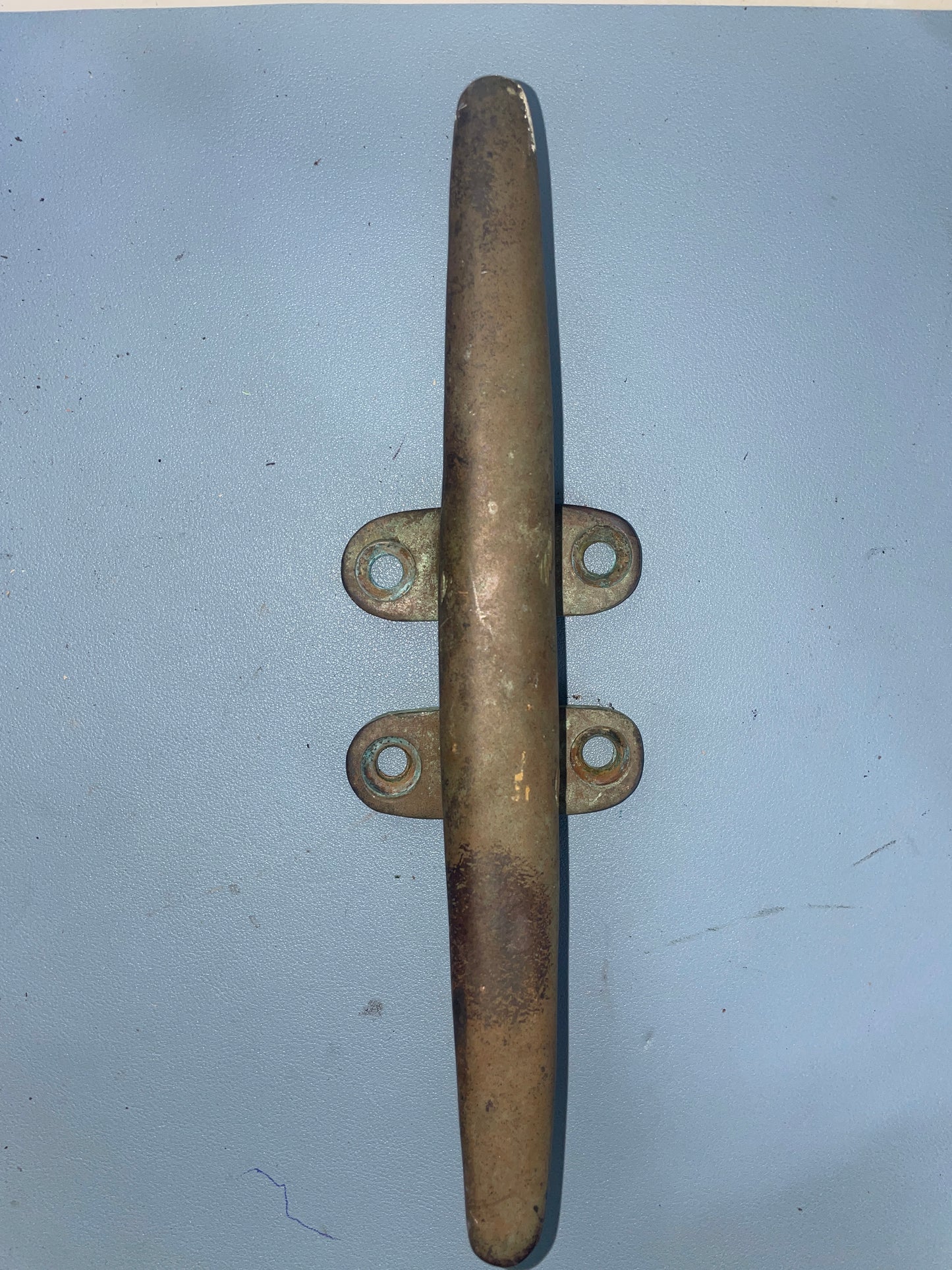 Brass cleat on a light blue background