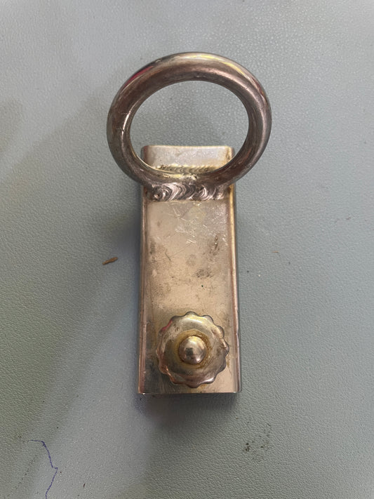 Metal bottle opener with ring on a gray background