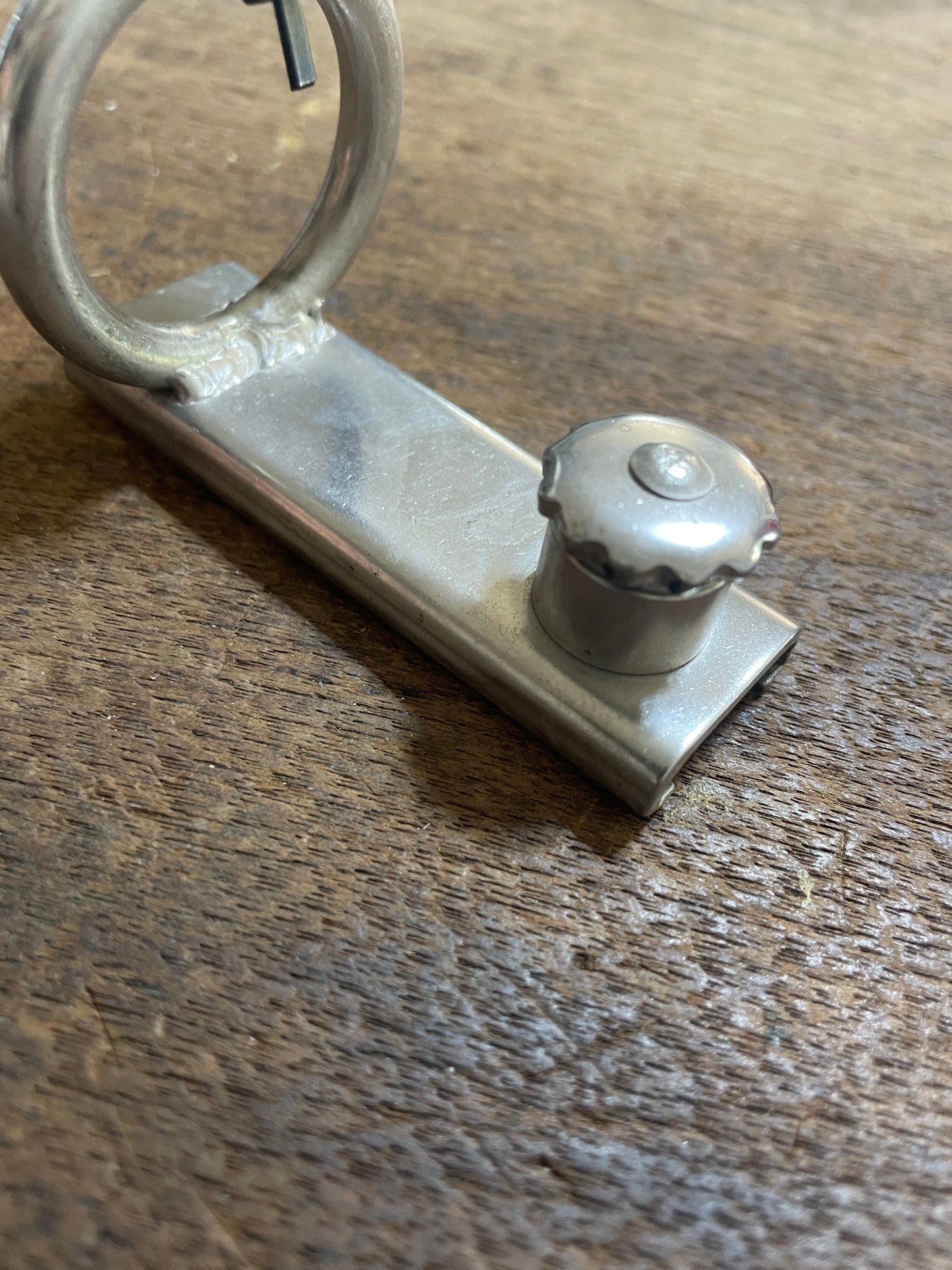 Metal keychain with a key on a wooden surface