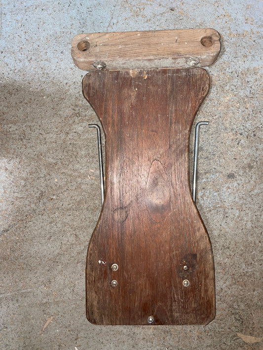 Wooden boot jack on a concrete floor