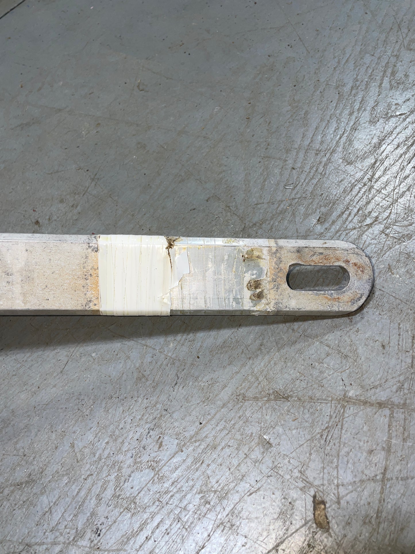 Metal tool with a handle on a textured concrete surface