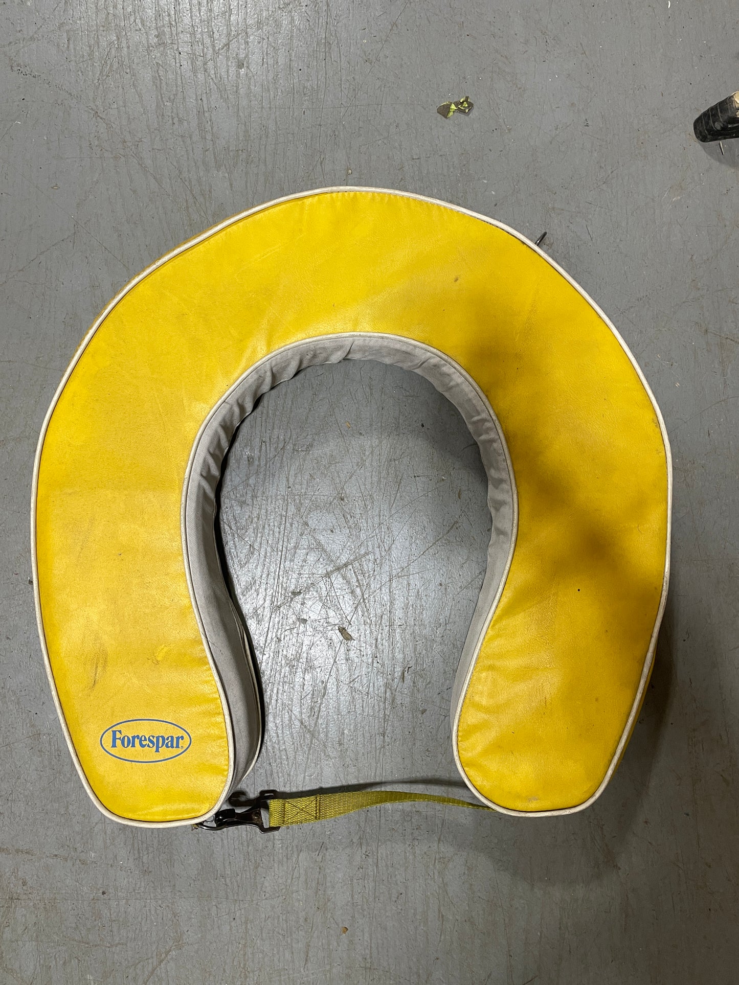 Yellow and gray travel pillow on a gray floor