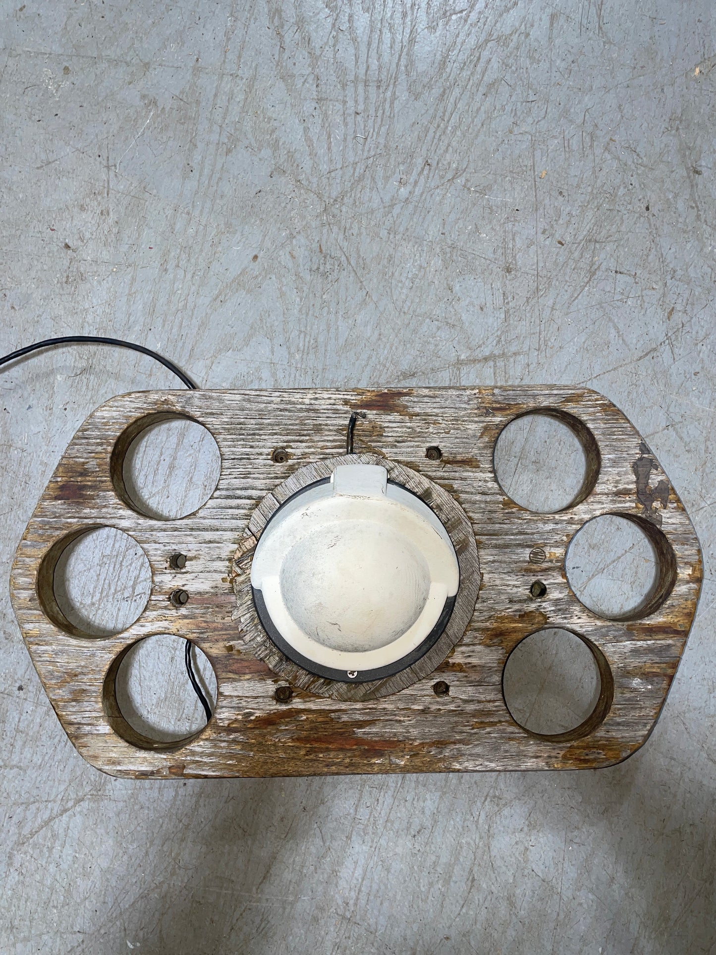 Wooden light fixture with a bulb on a textured surface