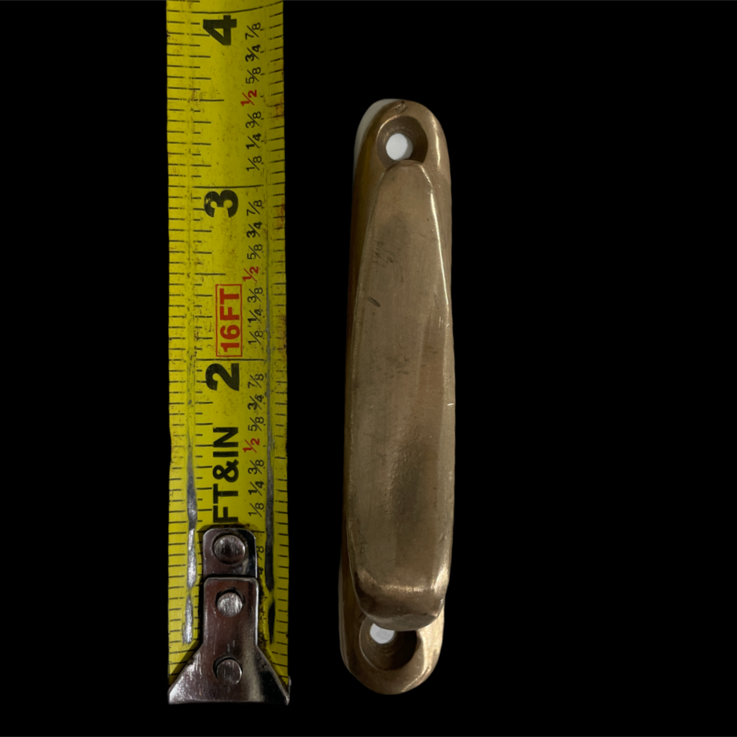Brass handle with a measuring tape on a black background