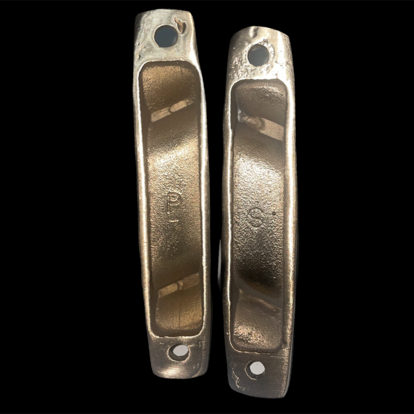 Two metallic door handles on a black background