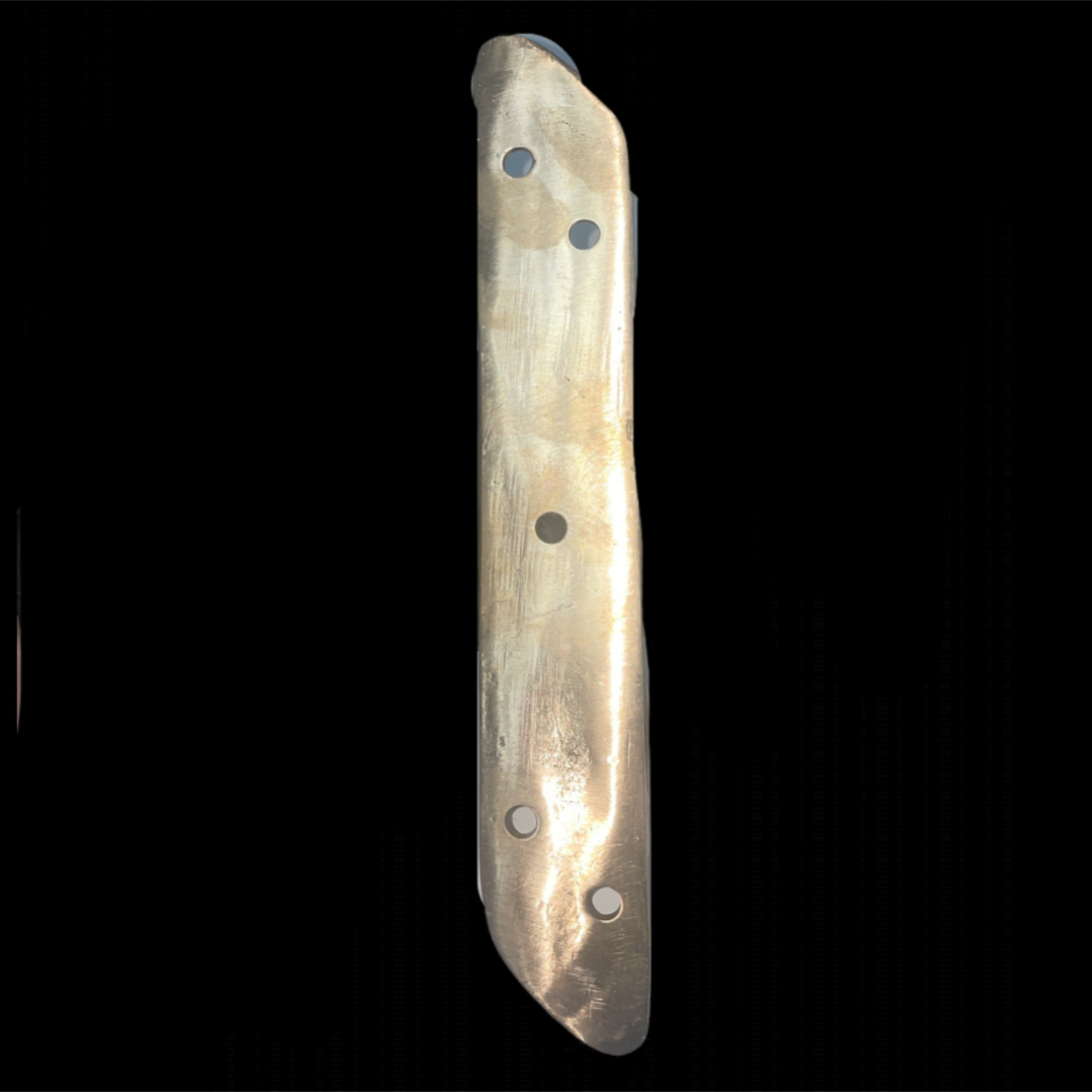 Long, thin stone tool with four holes on a black background