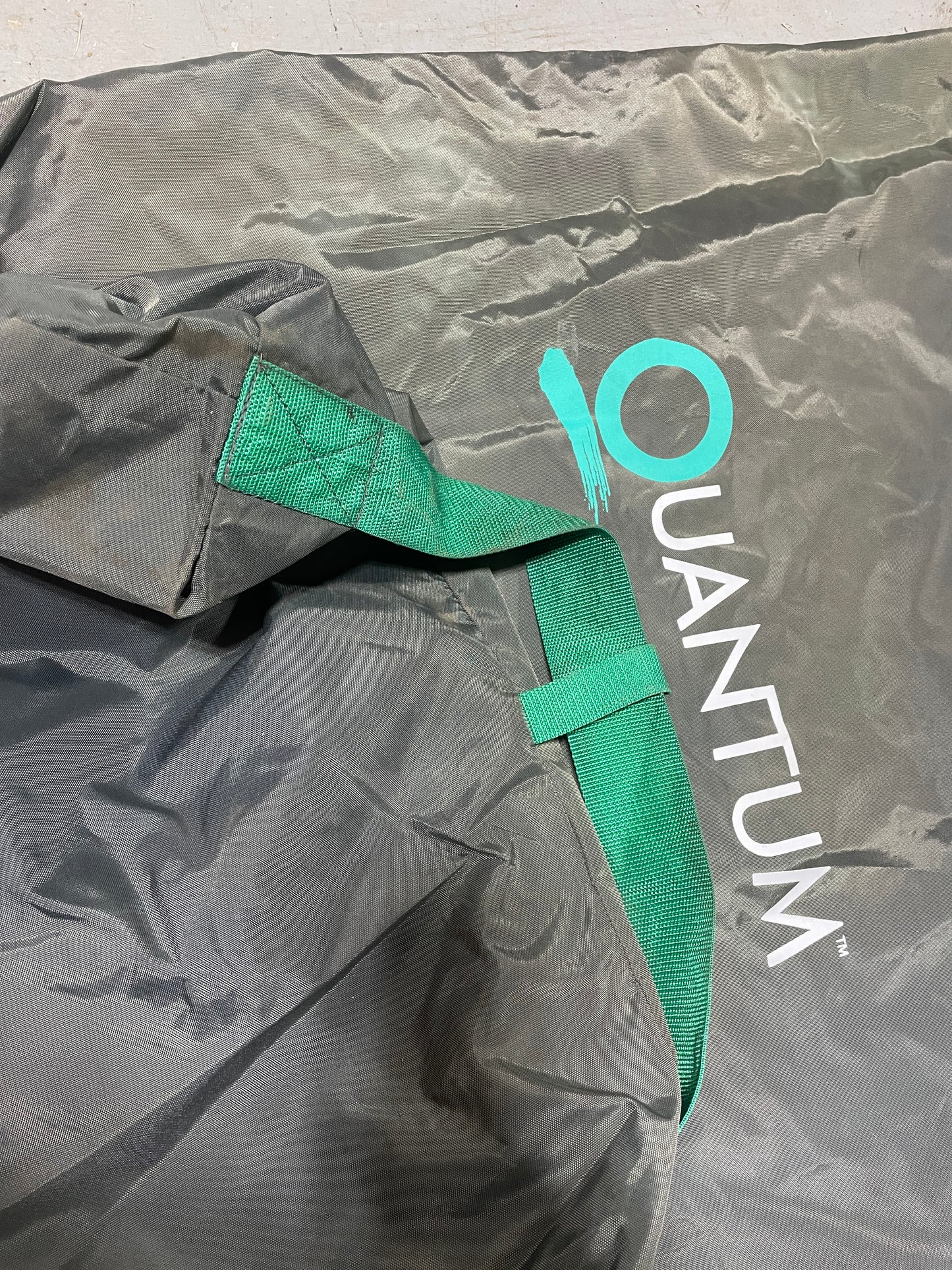 Gray bag with green strap and 'QUANTUM' logo on a light gray background