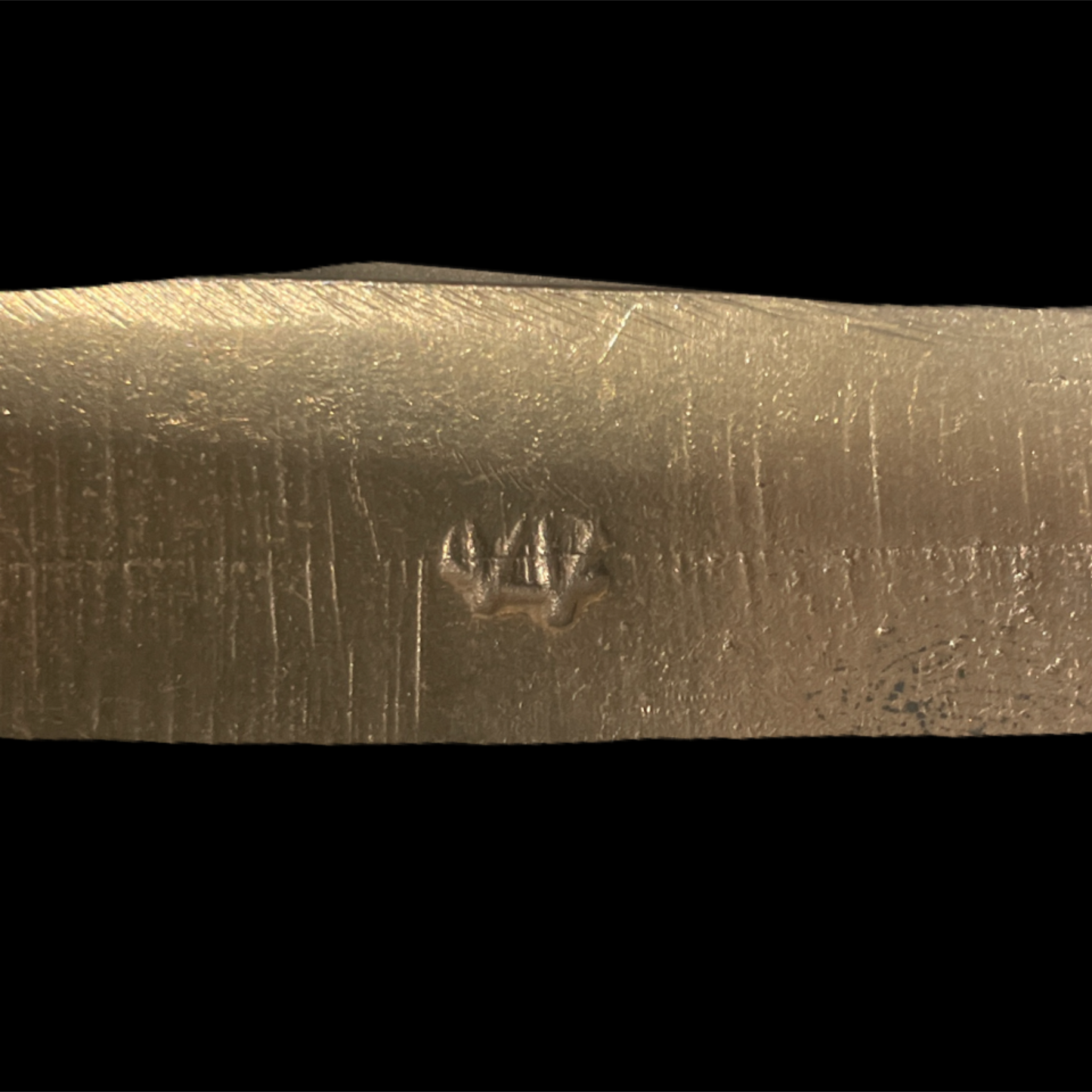 Close-up of a textured metallic object with a star-like symbol on a black background