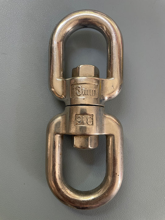 Bronze metal swivel eye bolt on a gray background