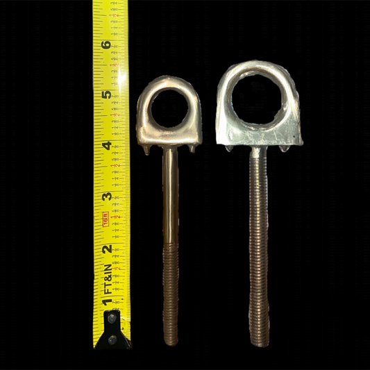 Two metal eye bolts with a yellow measuring tape on a black background