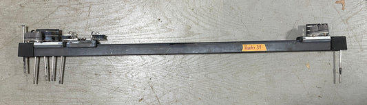 Long metal tool with various attachments on a gray surface