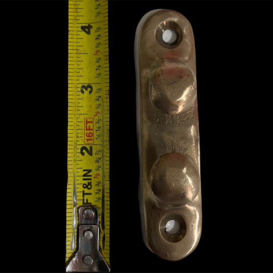 Metal clevis with measurement tape on a black background