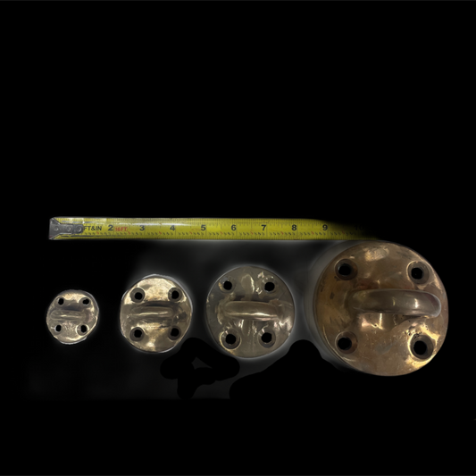 Set of metal components with a tape measure for scale on a black background