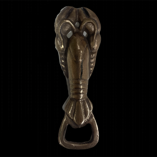 Bronze bottle opener shaped like a cobra on a black background