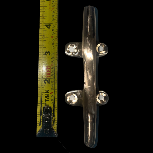 Metal cleat with a measuring tape on a black background