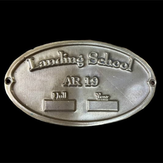 Metal plaque with 'Landing School AR 19' text on a black background