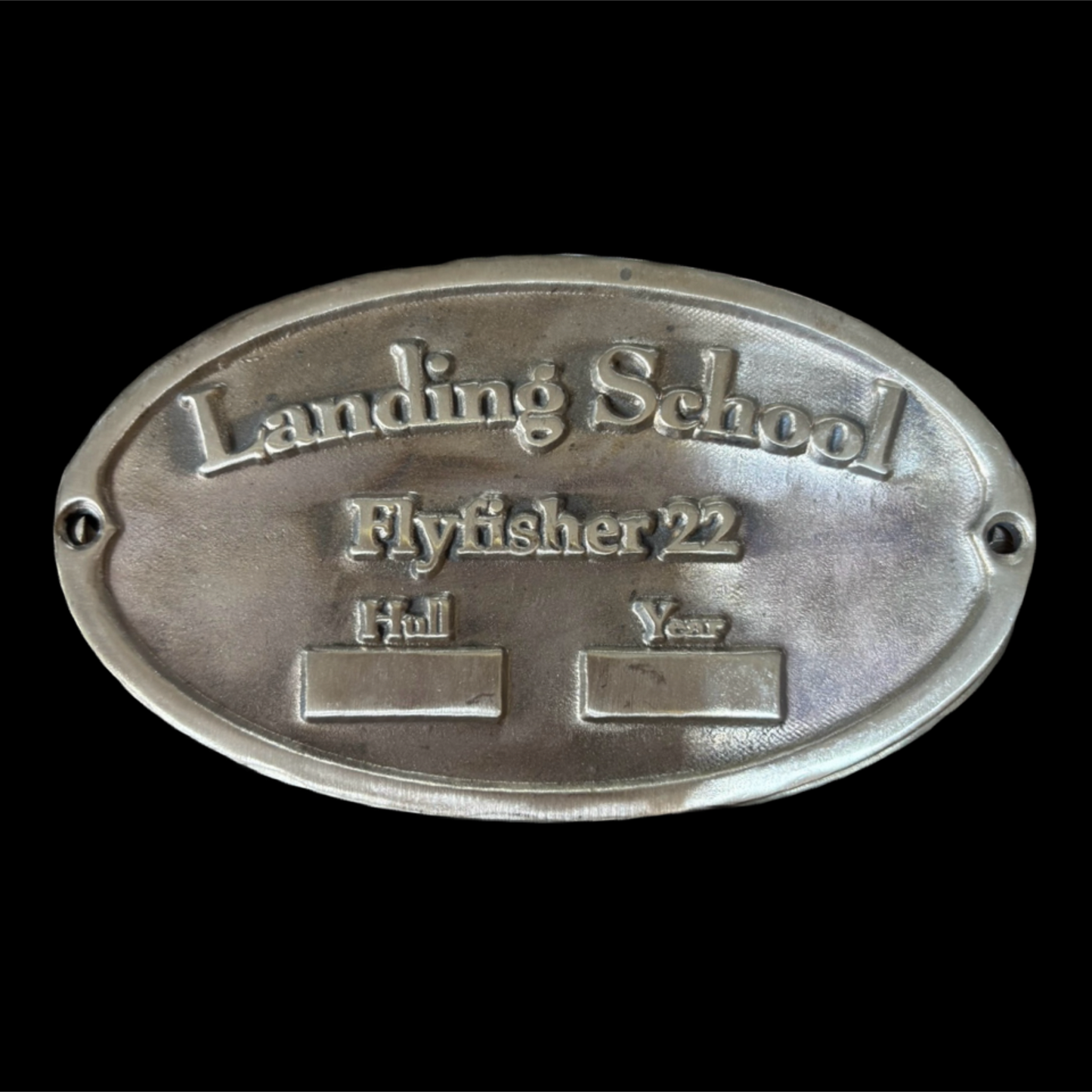 Metal plaque with 'Landing School Flyfisher 22' text on a black background