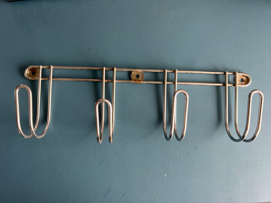 Metal wall-mounted rack with hooks on a blue background