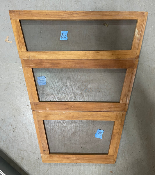 Wooden screen door with glass panels on a concrete floor