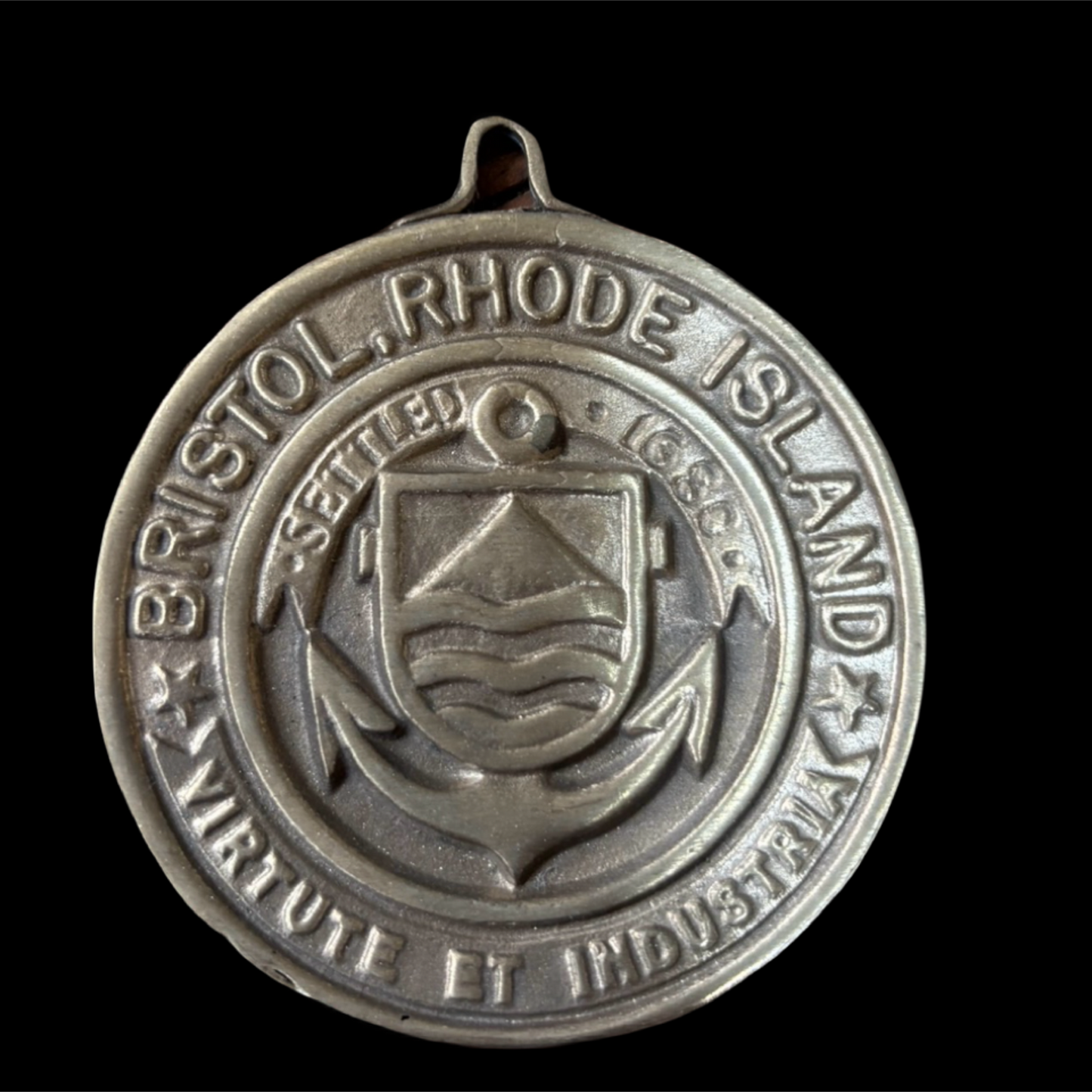 Silver medal with 'Bristol, Rhode Island' text and emblem on a black background