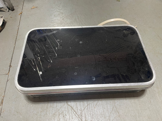 Black rectangular object with a reflective surface on a gray floor