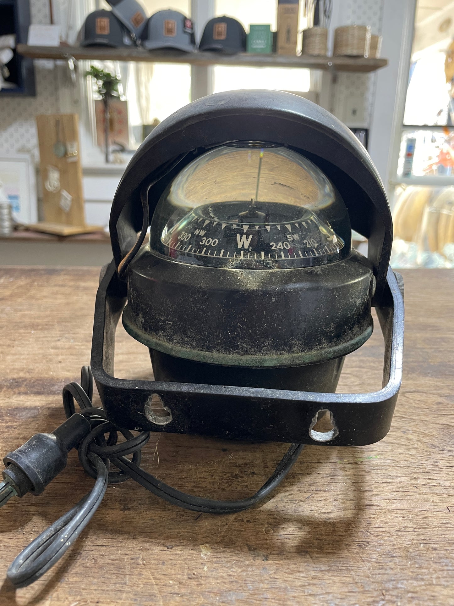 Vintage-style compass on a wooden surface with blurred background