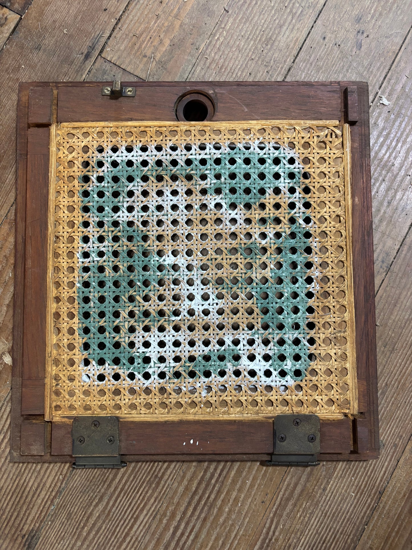 Decorative woven panel with a wooden frame on a wooden surface